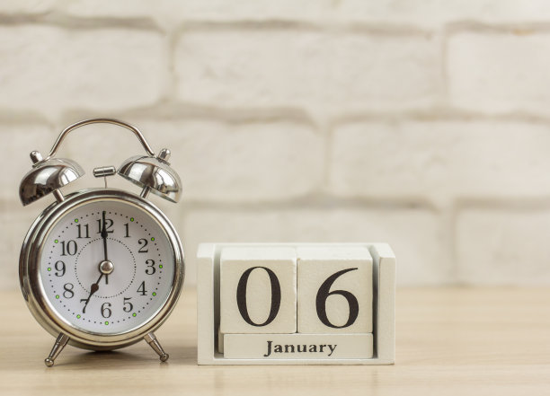 在1月6日的一个木制日历旁边的闹钟。一月的一天。冬天的一天。空间的拷贝。图片下载