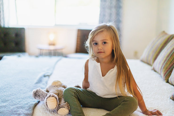 小女孩坐在床上和泰迪熊照片系列图片下载