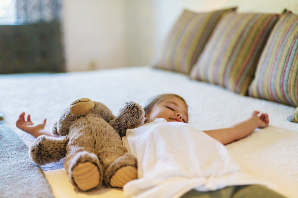 小女孩坐在床上和泰迪熊照片系列图片下载