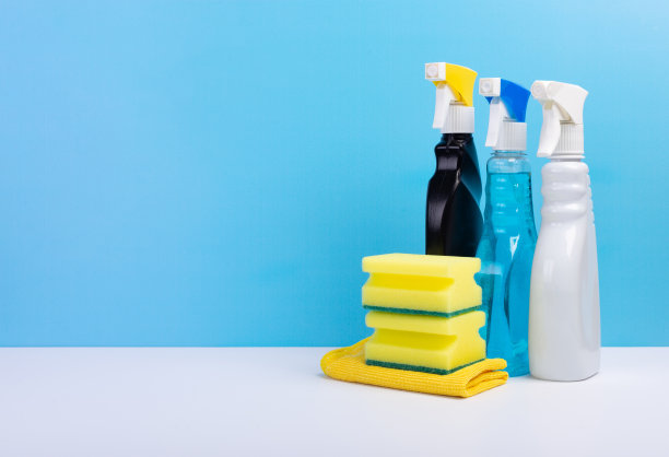 窗户清洁剂在一个彩色的塑料喷瓶和海绵在蓝色的背景。清洗的概念图片下载