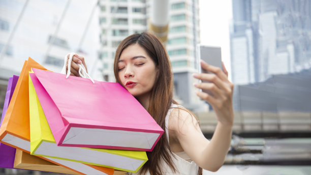 购物肖像的年轻快乐微笑的女人与购物袋。生活方式的概念。图片下载