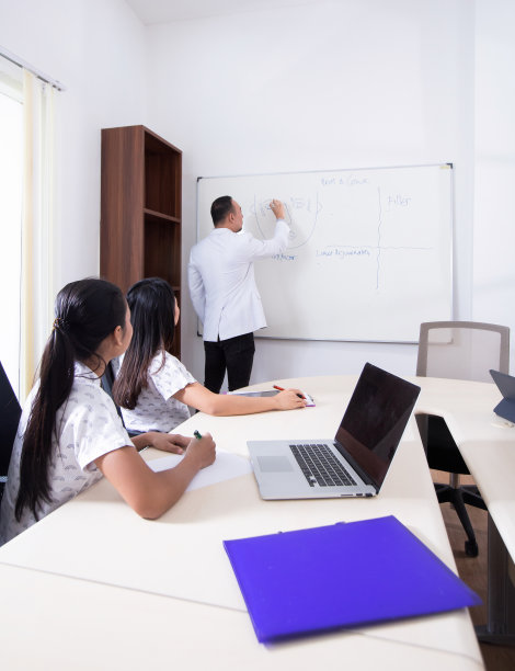 一群医务人员在办公室举行商务会议、会议、研讨会。团队成员在白板前聆听一位兴高采烈的医生演讲图片下载