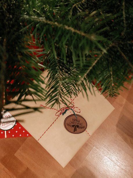 红色和棕色的圣诞礼物包裹在圣诞树下的礼物标签说“圣诞快乐”，为一个舒适的家庭在家里的圣诞节在2020年图片下载