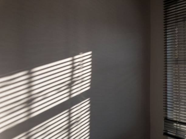 影子楼。抽象的光线，黑色的阴影从窗户覆盖在白色纹理的墙壁上。阳光建筑背景。叠加效果的照片和设计。图片下载