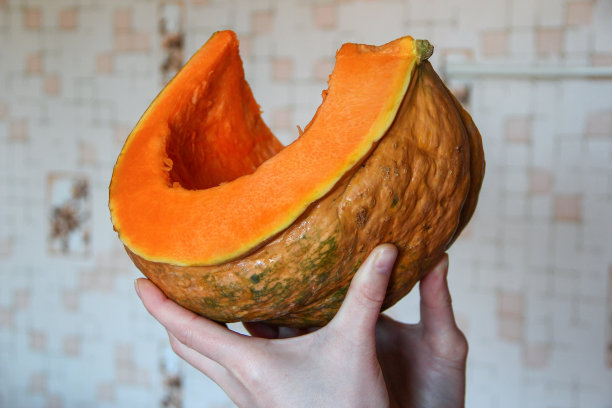 女人手里拿着一大块成熟的南瓜图片下载