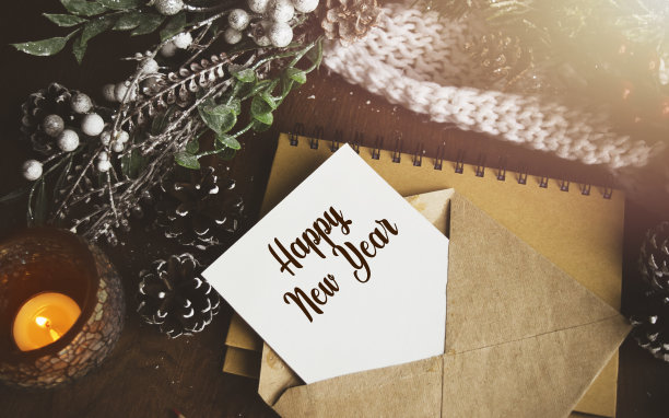 在旧信封的白纸上写着新年祝福语，背景是新年的装饰。从以上观点。圣诞节或冬季的规划概念。图片下载