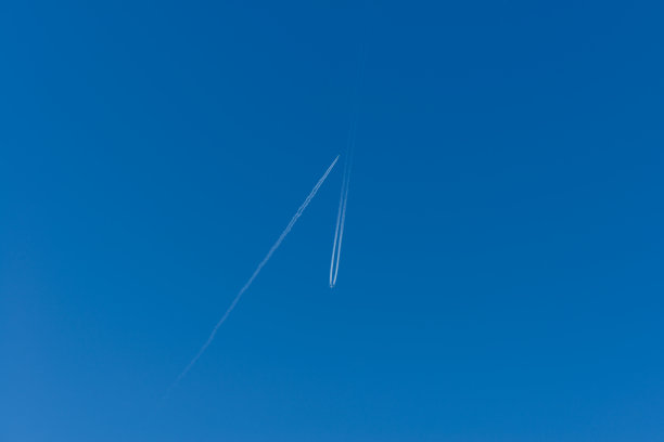蓝色天空中两架客机的尾迹图片下载