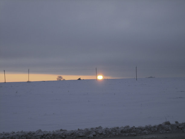 路边鲜红的晚霞笼罩着冬日的田野。图片下载