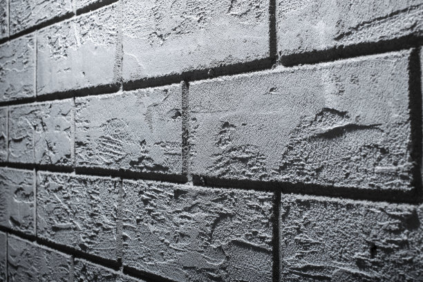 用水泥石膏手工制作的撕裂砖的纹理，前面和背景模糊，有散景效果图片下载