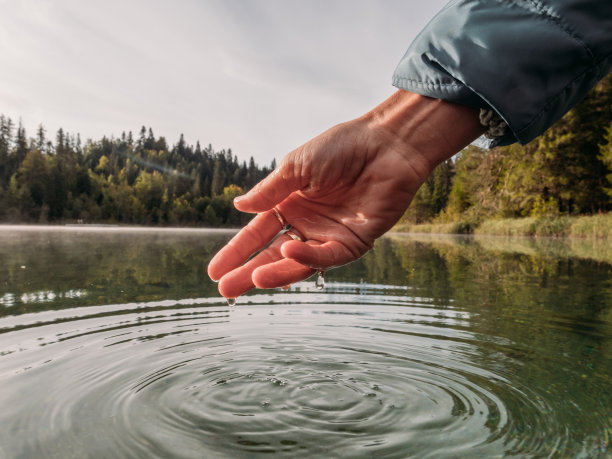 手从高山湖舀水图片下载