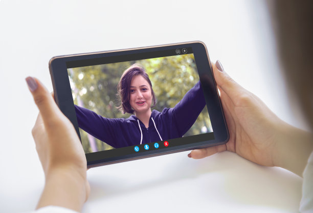 手持智能手机在手机屏幕上与年轻的女友交流，使用手机进行视频通话移动社交媒体约会应用程序。视频通话概念。过肩近看。图片下载