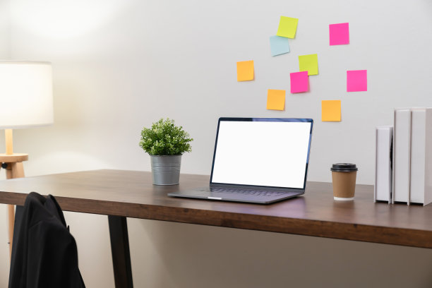 现代办公室桌上的黑屏笔记本电脑。模型的广告。图片下载