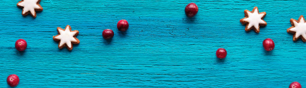 自然的圣诞装饰品。星形姜饼和红莓。平躺在绿松石木材上图片下载