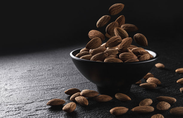 下落的杏仁坚果在黑色背景与复制空间图片下载
