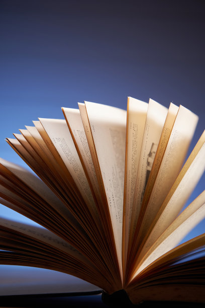 一个扇形的书与棕色的纸页对着蓝色的背景的特写图片下载