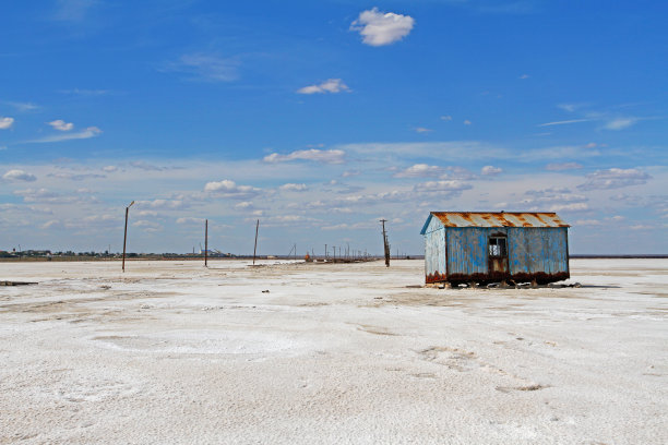 Baskunchak盐湖，废弃的旧蓝色金属房子，背景是柱子图片下载