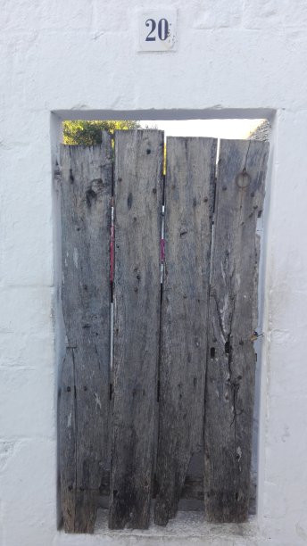 白色泥墙里的旧木门图片下载