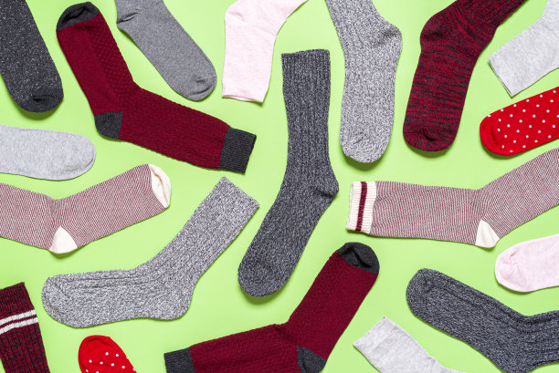 许多袜子在一个绿色的背景以上的观点。图案与多色袜子图片下载
