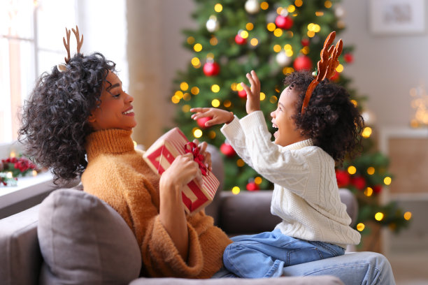 快乐的民族母亲和儿子在家里庆祝圣诞节图片下载