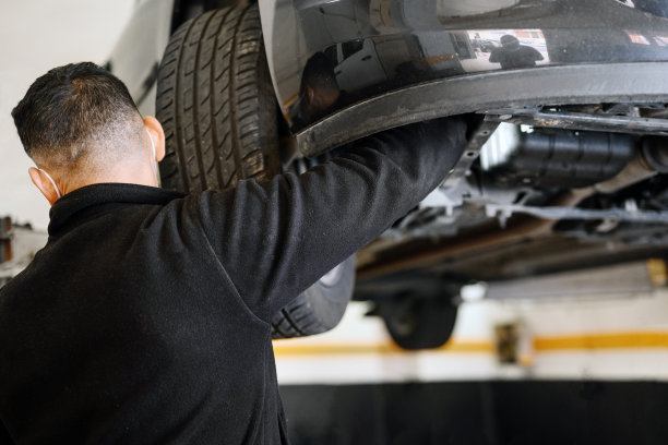 专业机械师戴着防护面罩，在维修厂修车。高质量的照片图片下载