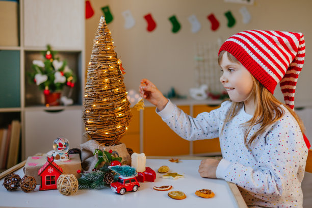 小女孩在室内装饰圣诞树图片下载