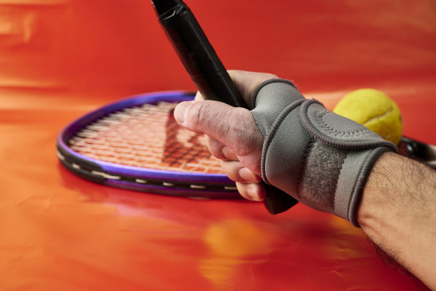 男人的手带腕带和网球拍图片下载