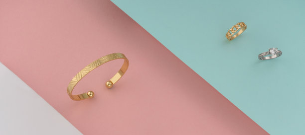 金色的手镯和戒指与钻石在彩色的背景图片下载