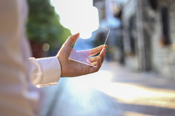 西装男子的手，使用了最新先进全息技术的未来玻璃电话。概念:未来、科技、智能手机、增强现实。图片下载