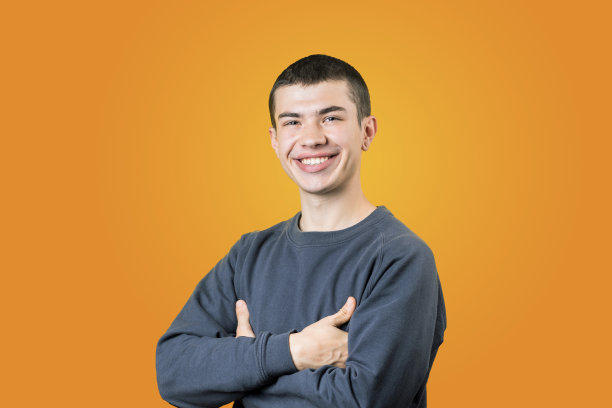 快乐微笑的年轻人摆姿势在工作室拍摄橙色背景。生活方式的肖像。穿着休闲衣服的男人。看相机。积极情绪的概念图片下载