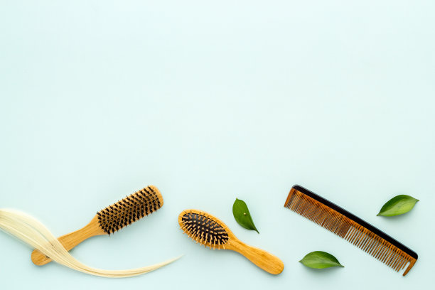 用竹梳和药草梳成的金色卷发。俯视图平铺图片下载