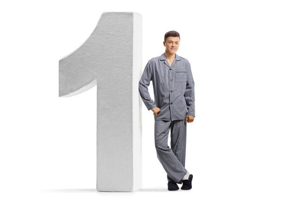 一个穿着睡衣靠在墙上的男性少年的全身像图片下载