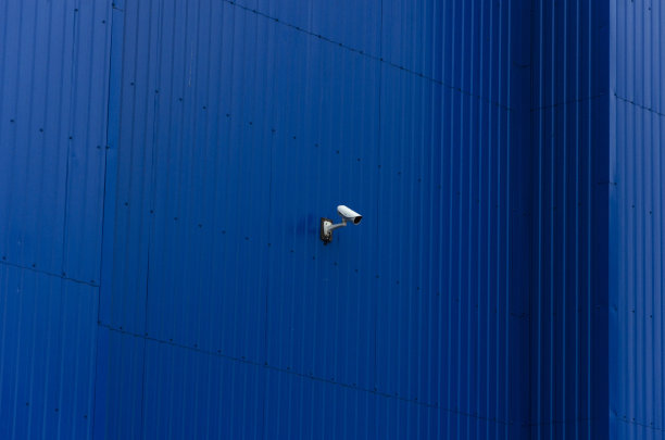 达尔，建筑的蓝色墙壁上有白色摄像头。空白的表面图片下载