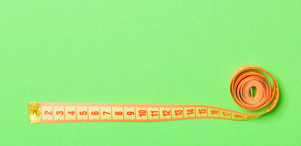 用卷尺制成的框架，在绿色背景上。俯视图的缝纫概念。细腰概念与空间为您的设计图片下载