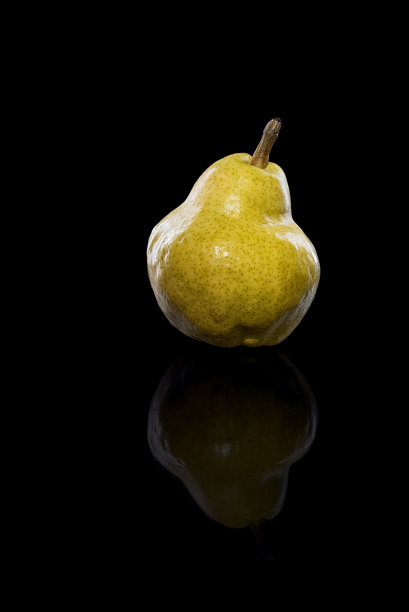 成熟的梨子果实呈黄色，带有反光，孤立在黑色上图片下载