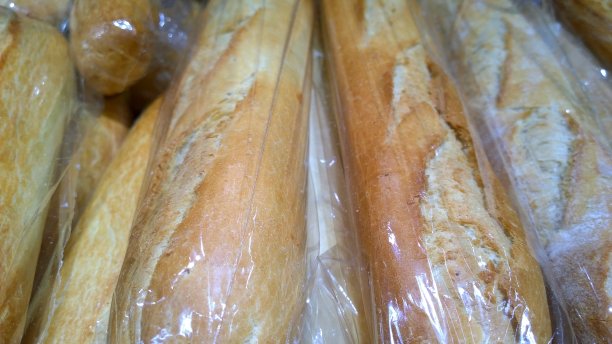 包装中的法式长棍面包。烤面包。热的新鲜小麦长面包。面包制作和烘焙食品的概念。自然的烘焙产品。零售行业。关闭了。外卖和网购。图片下载