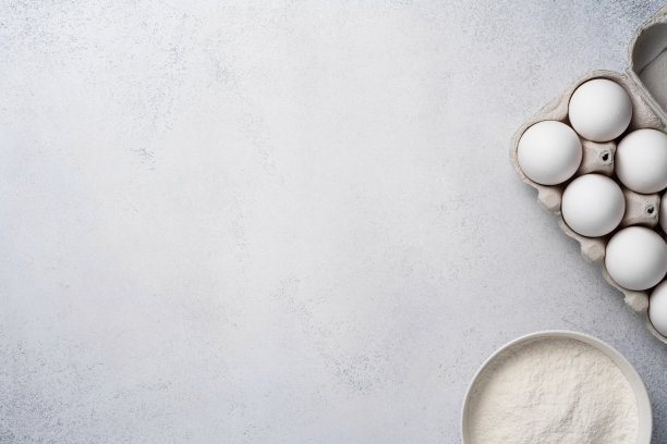 烘焙原料。灰色的背景上是小麦粉和白鸡蛋。图片下载