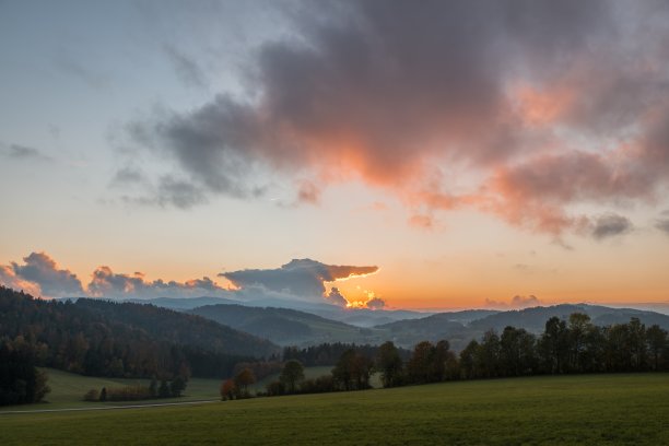 风景和日落草地森林树木山附近的格拉芬瑙在巴伐利亚森林与云彩和阳光，德国图片下载