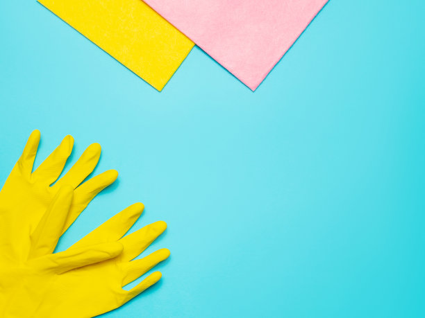 超细纤维和厨房乳胶手套，蓝色背景，俯视图。清洁用品。图片下载