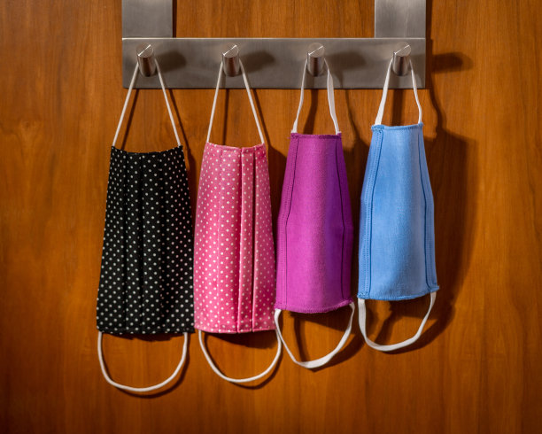 家里的门上挂着四个防护口罩。图片下载