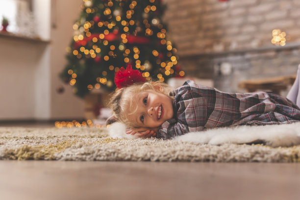 小女孩躺在圣诞树旁图片下载
