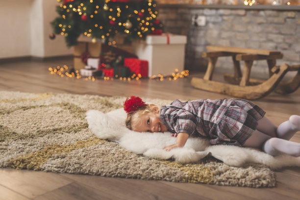 孩子躺在圣诞树旁图片下载