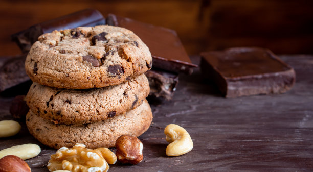 有机食品零食美味的甜甜点牛奶黑巧克力片盐饼干特写片水果橘子树莓榛子坚果肉桂可可可可粉木制桌子作为新年圣诞礼物图片下载