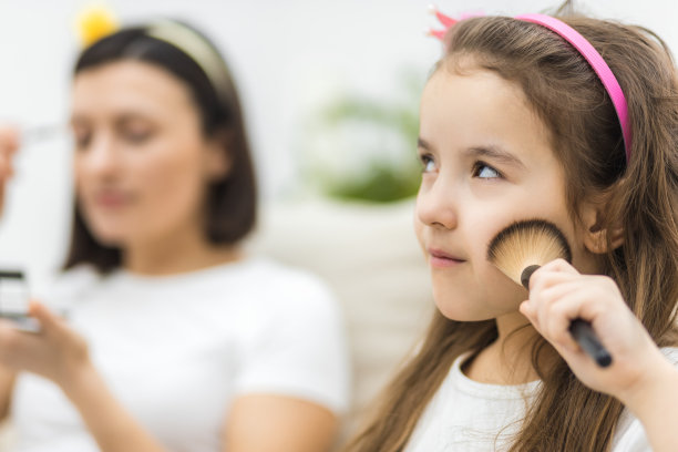 小女孩的照片和化妆品和她的母亲在附近。图片下载