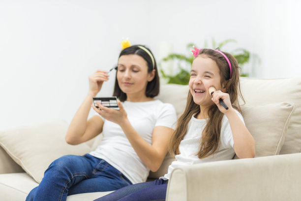 妈妈和小女儿的照片有乐趣和做化妆在一起。图片下载