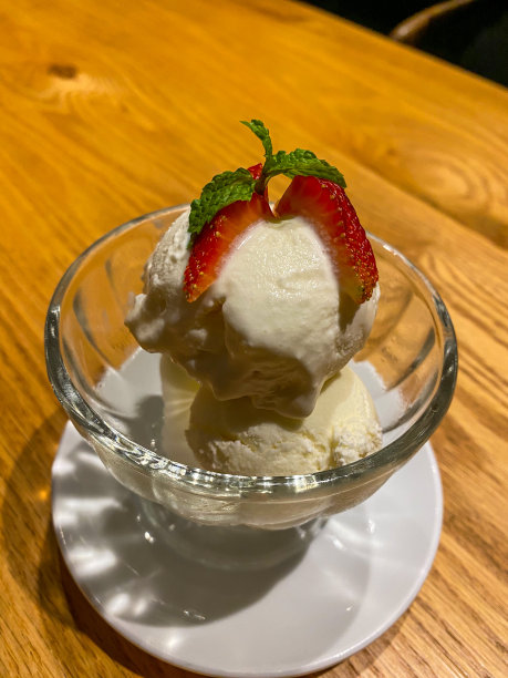 用草莓片装饰的冷冻酸奶球的垂直照片图片下载