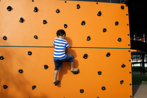 后视图完整长度的男孩爬墙户外图片下载