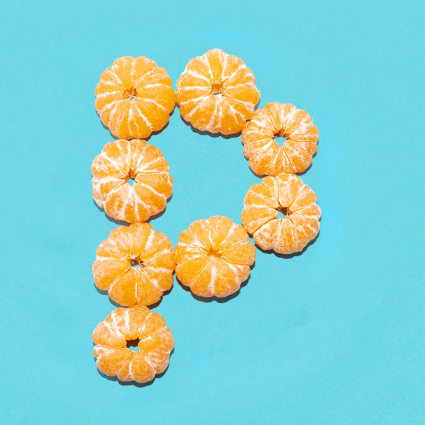 创造性地设计了字母P从去皮的橘子在蓝色的背景。Flatlay。图片下载