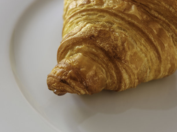 白盘子上的新鲜烤羊角面包图片下载