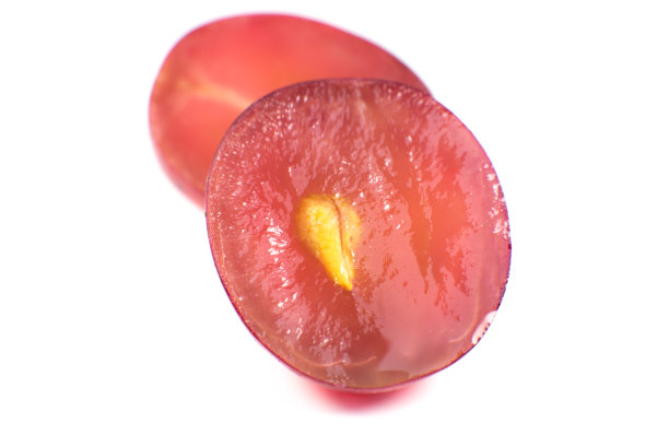 熟透的紫葡萄在白色的背景上切成两半。近距离的照片。纯素食者的生态水果。维生素。图片下载