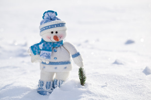 雪中长着胡萝卜鼻子的小雪人。图片下载